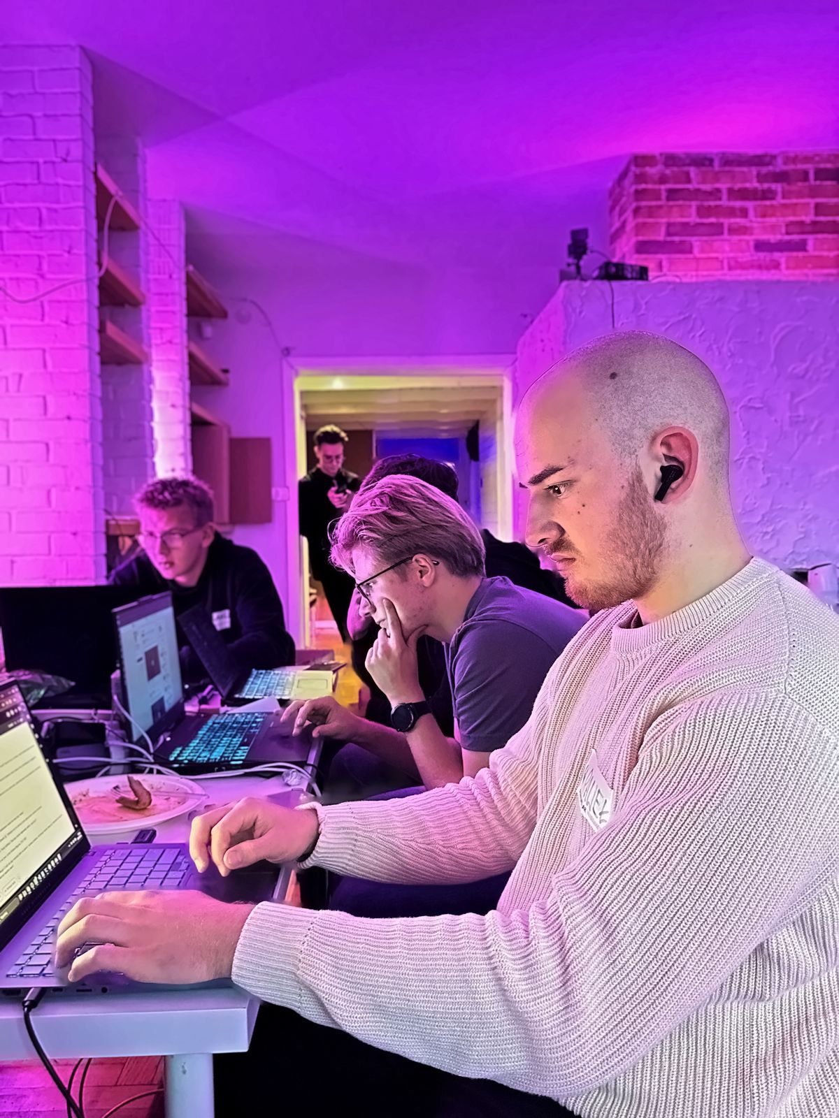 Uczestnicy hackathonu przy laptopach